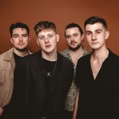 Four men stood in front of a red backdrop